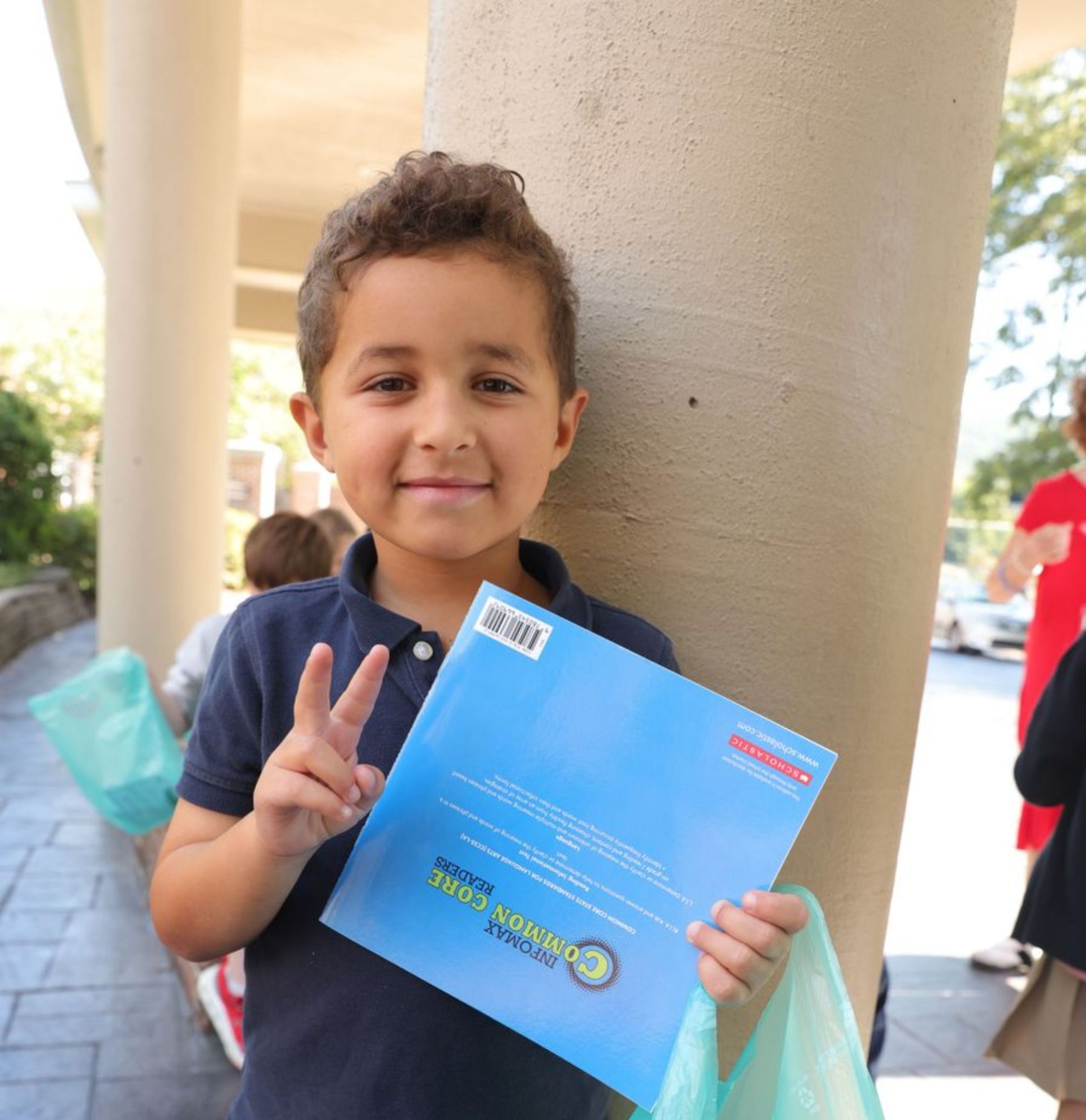 Student smiling while holding a book