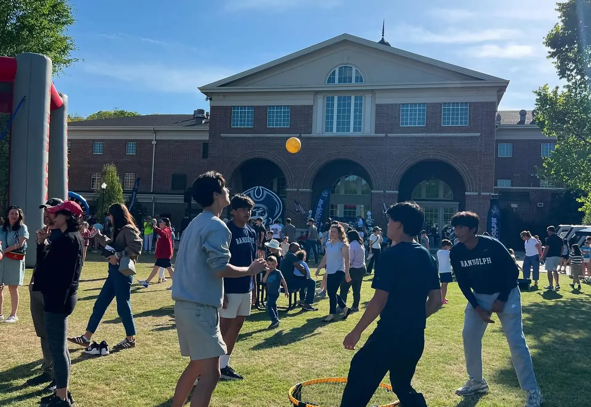 Students and families enjoying outdoor activities on the school lawn.