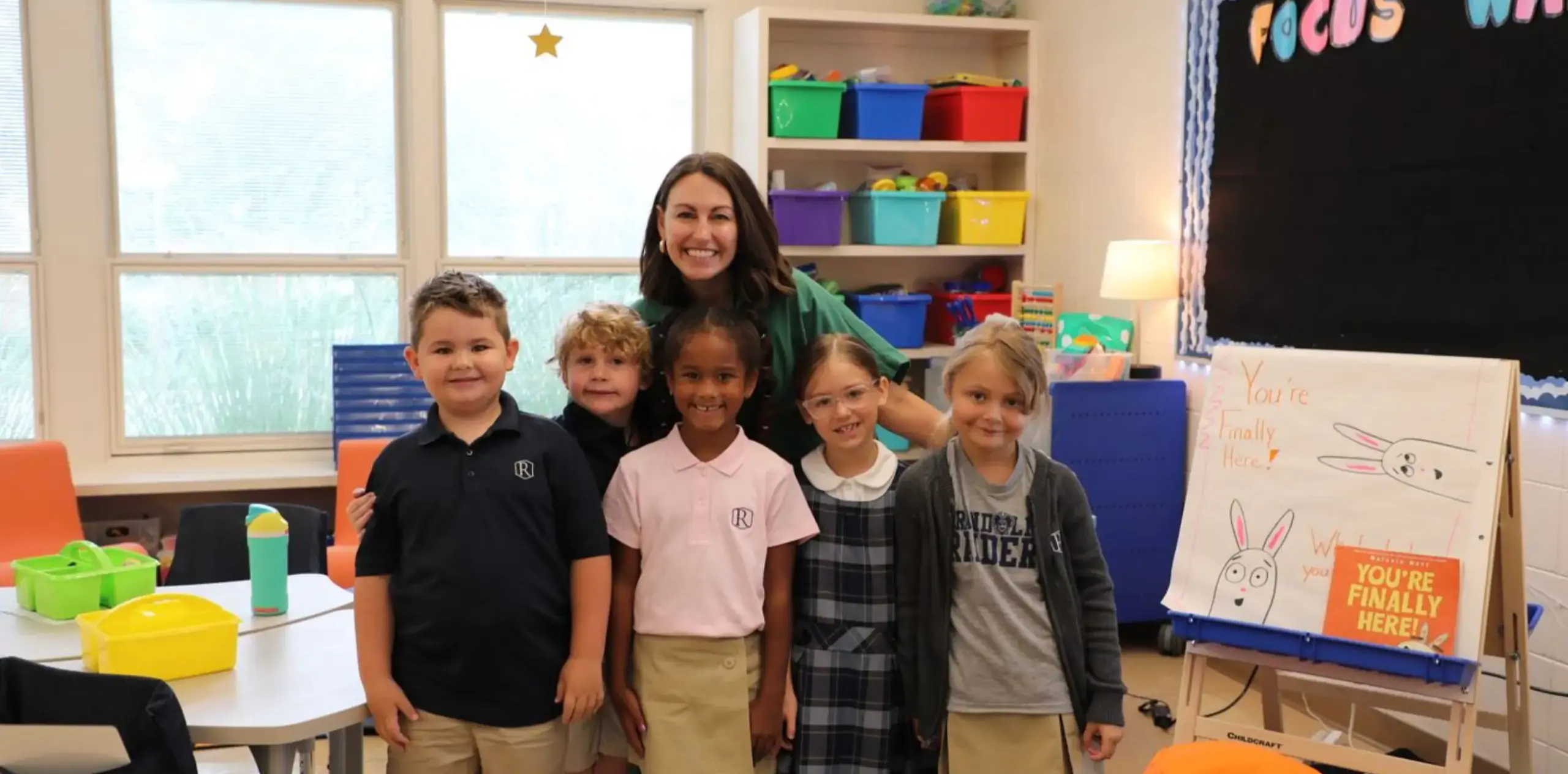 group photo of students smiling with their teacher