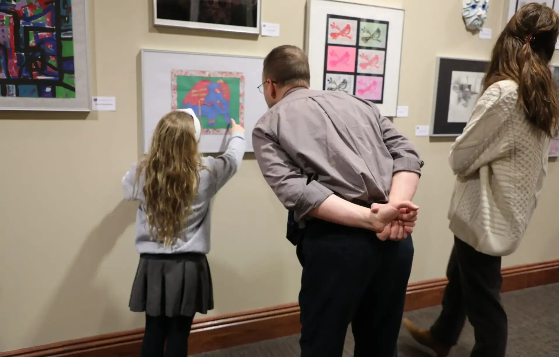 Student showing artwork to parents