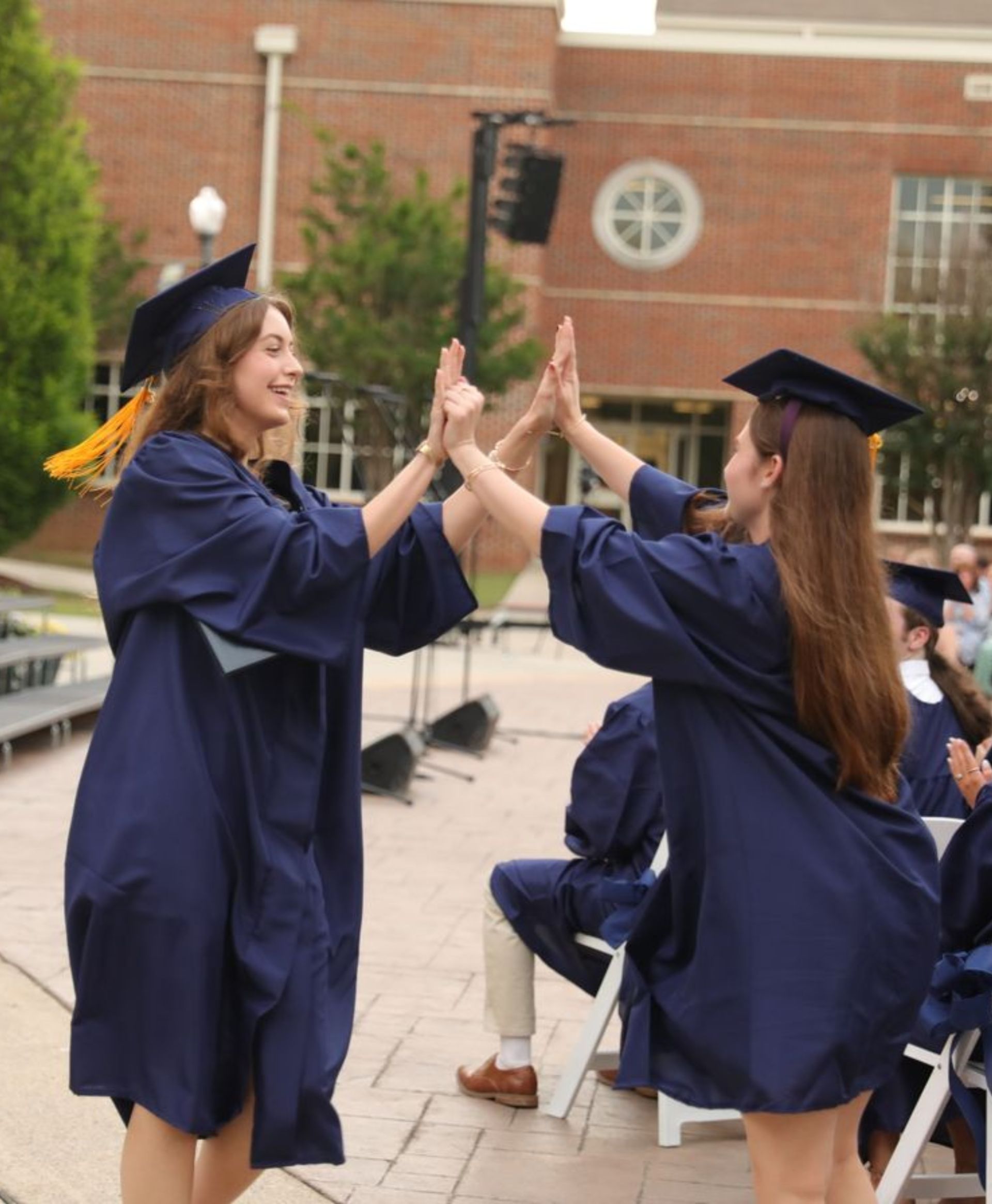 graduating students celebrating with a high five