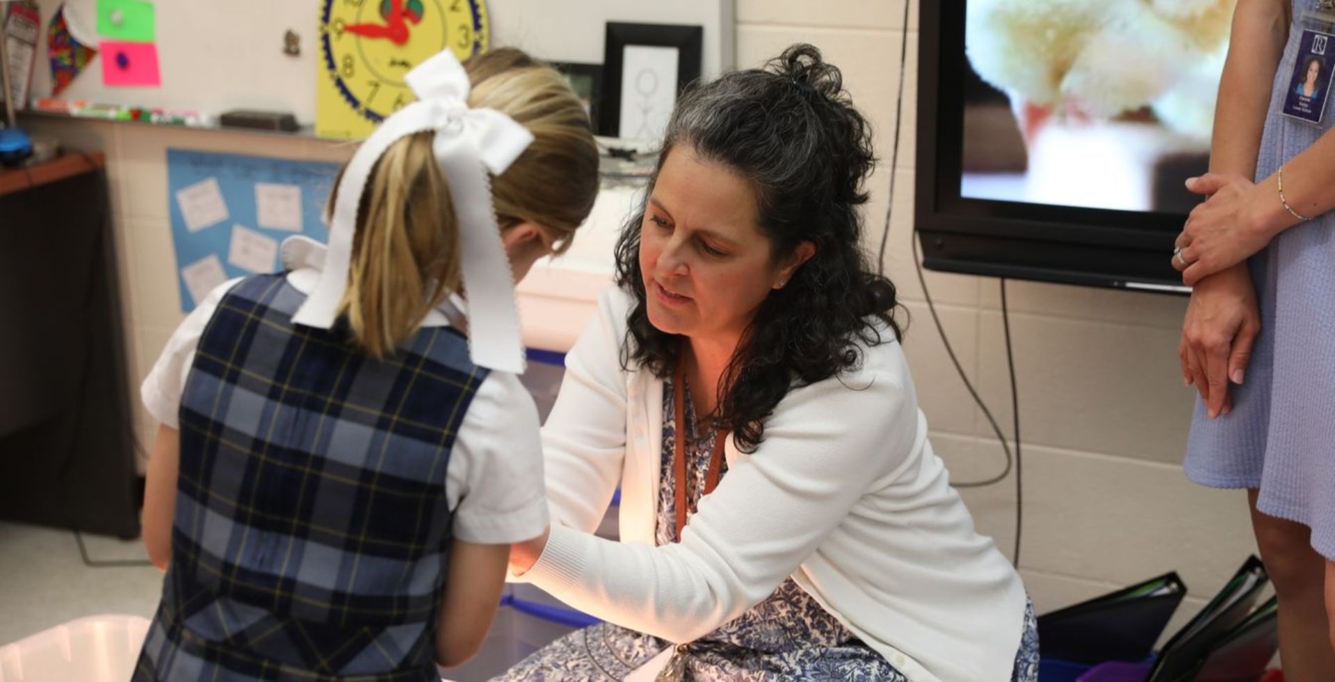 Teacher assisting a student with a classroom activity.