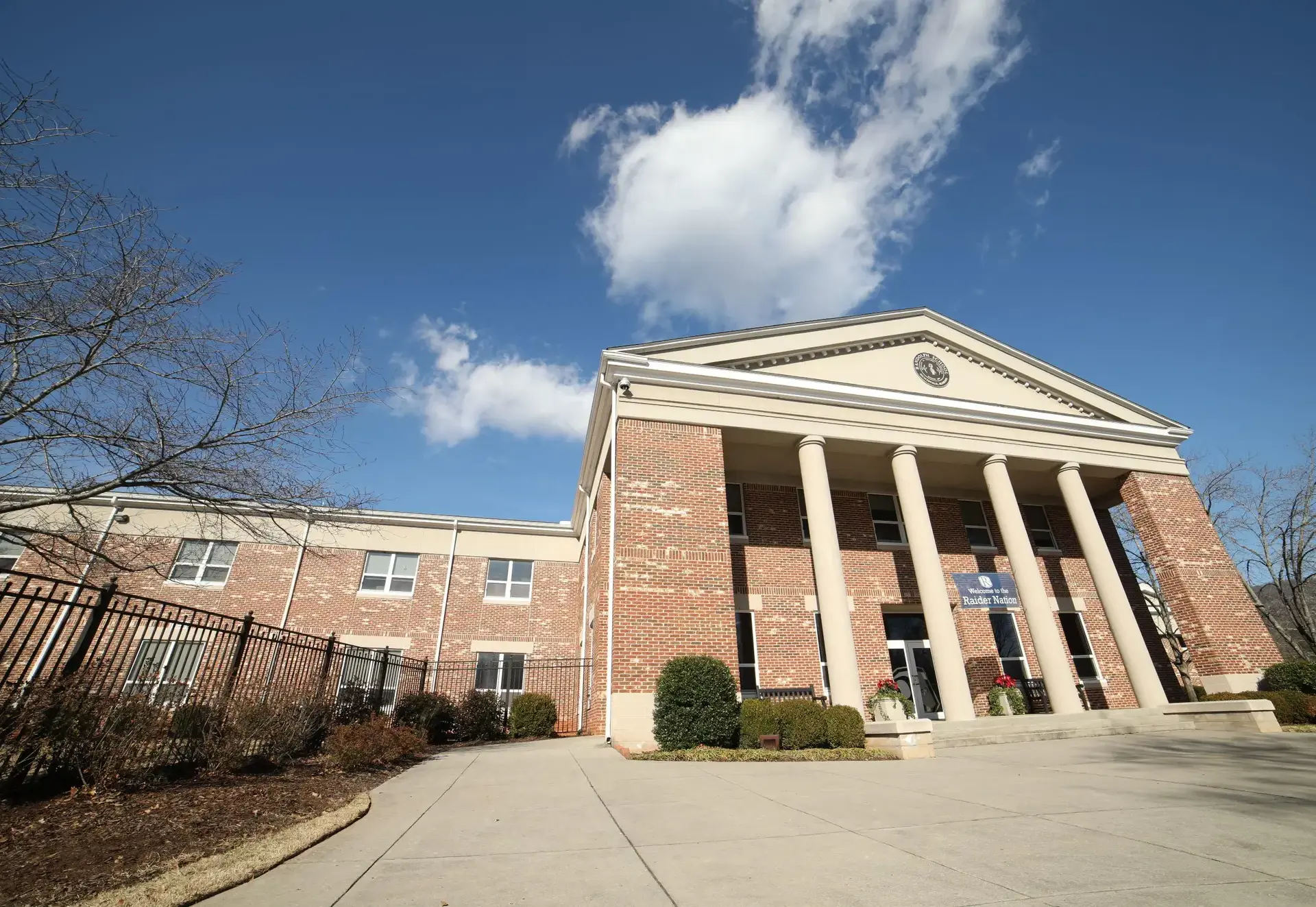 Exterior view of Randolph school building with columns and a brick facade.