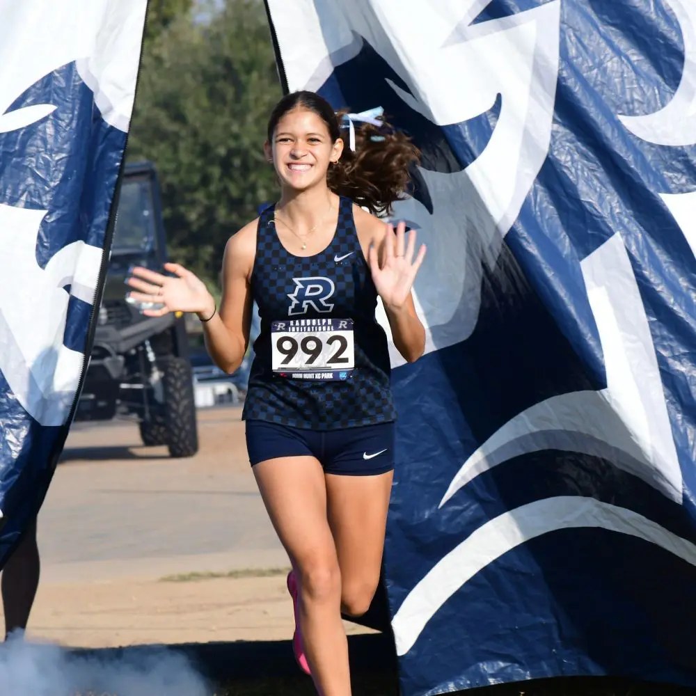 Cross Country runner comes in first place through the finish line. 