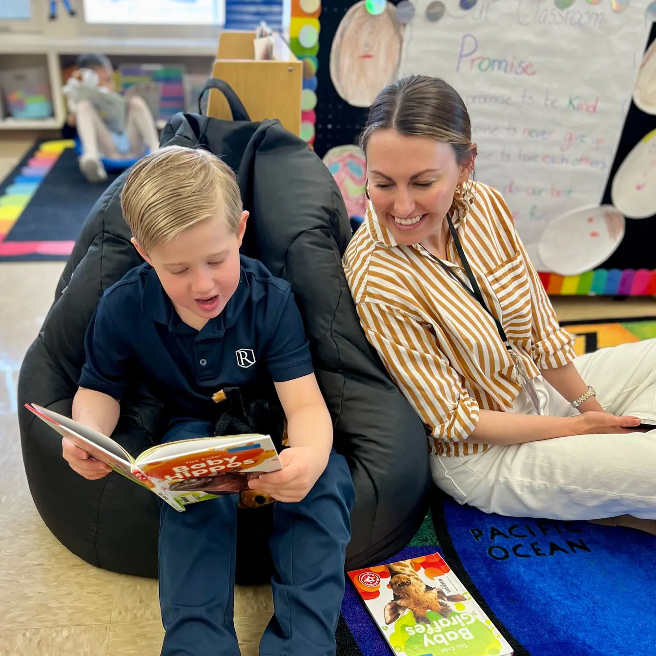 Student reading a book with teacher