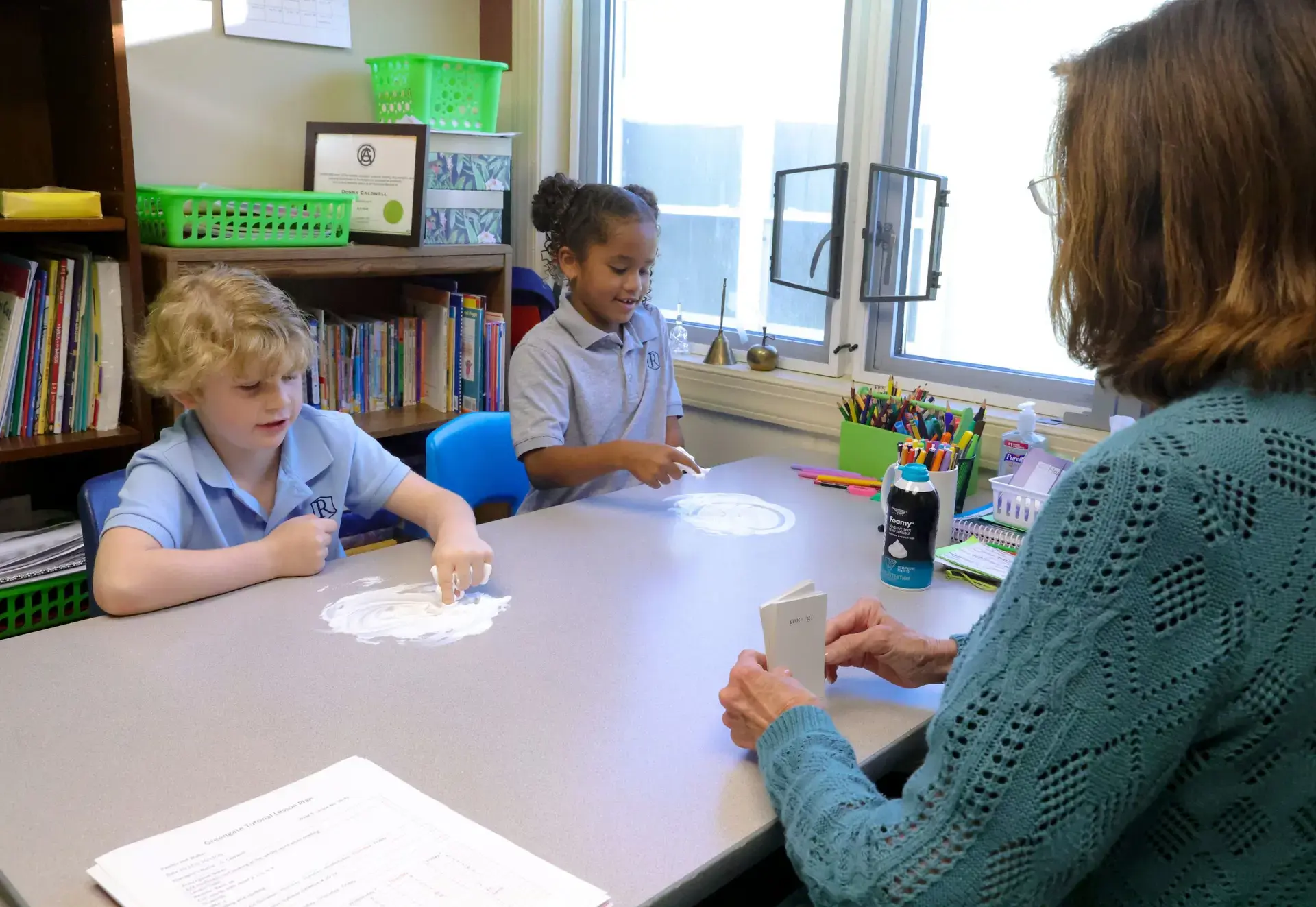 Students strengthen literacy skills through hands-on, multisensory learning—tracing letters in shaving cream as part of engaging, effective dyslexia instruction.