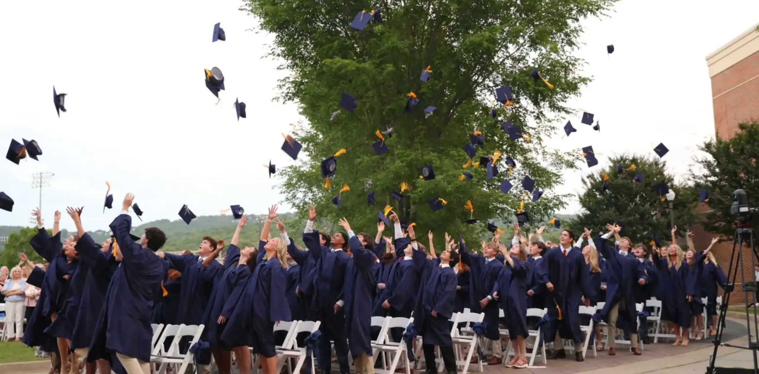 Graduating class throwing their caps into the air