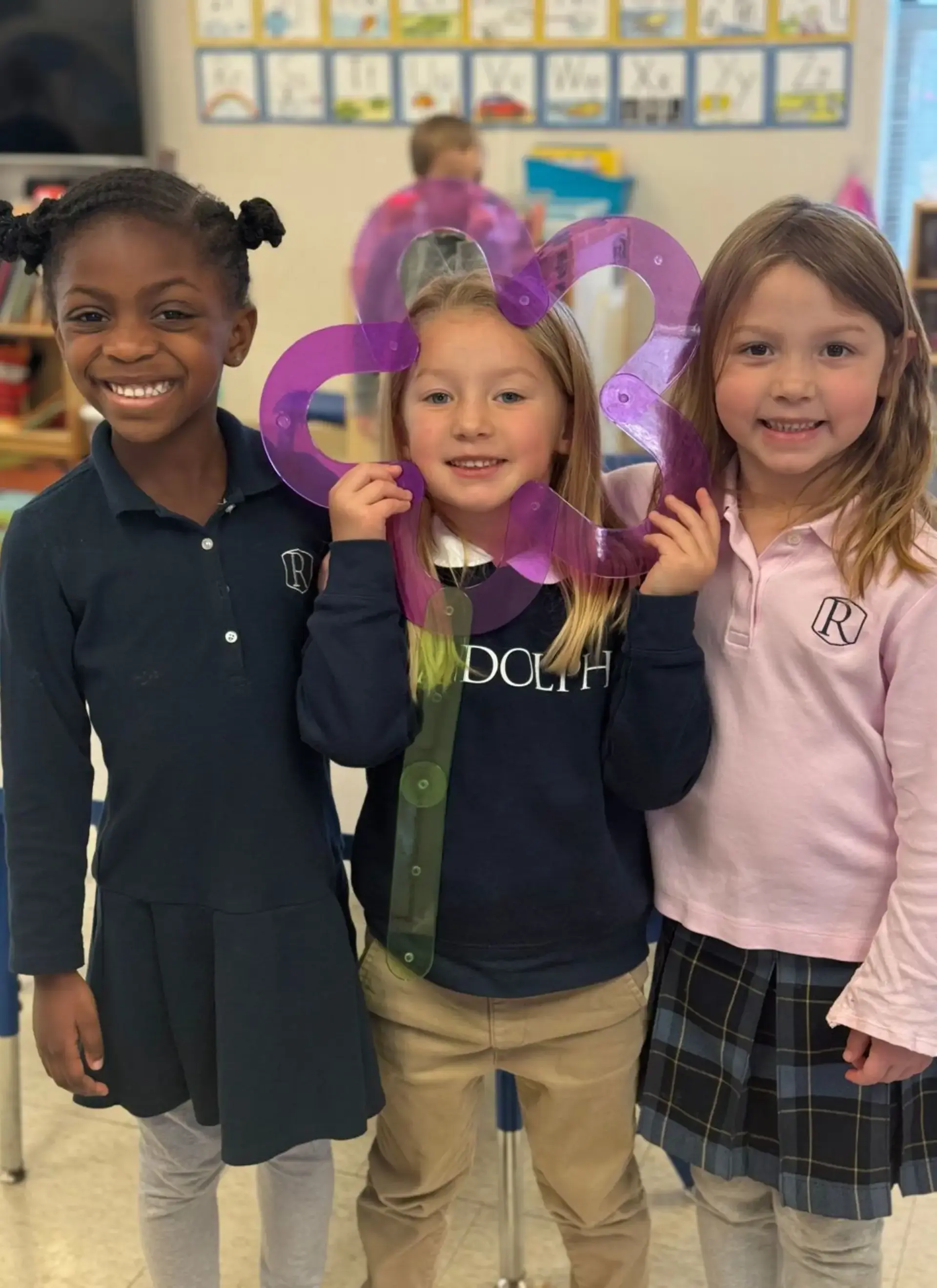 students smiling holding artwork