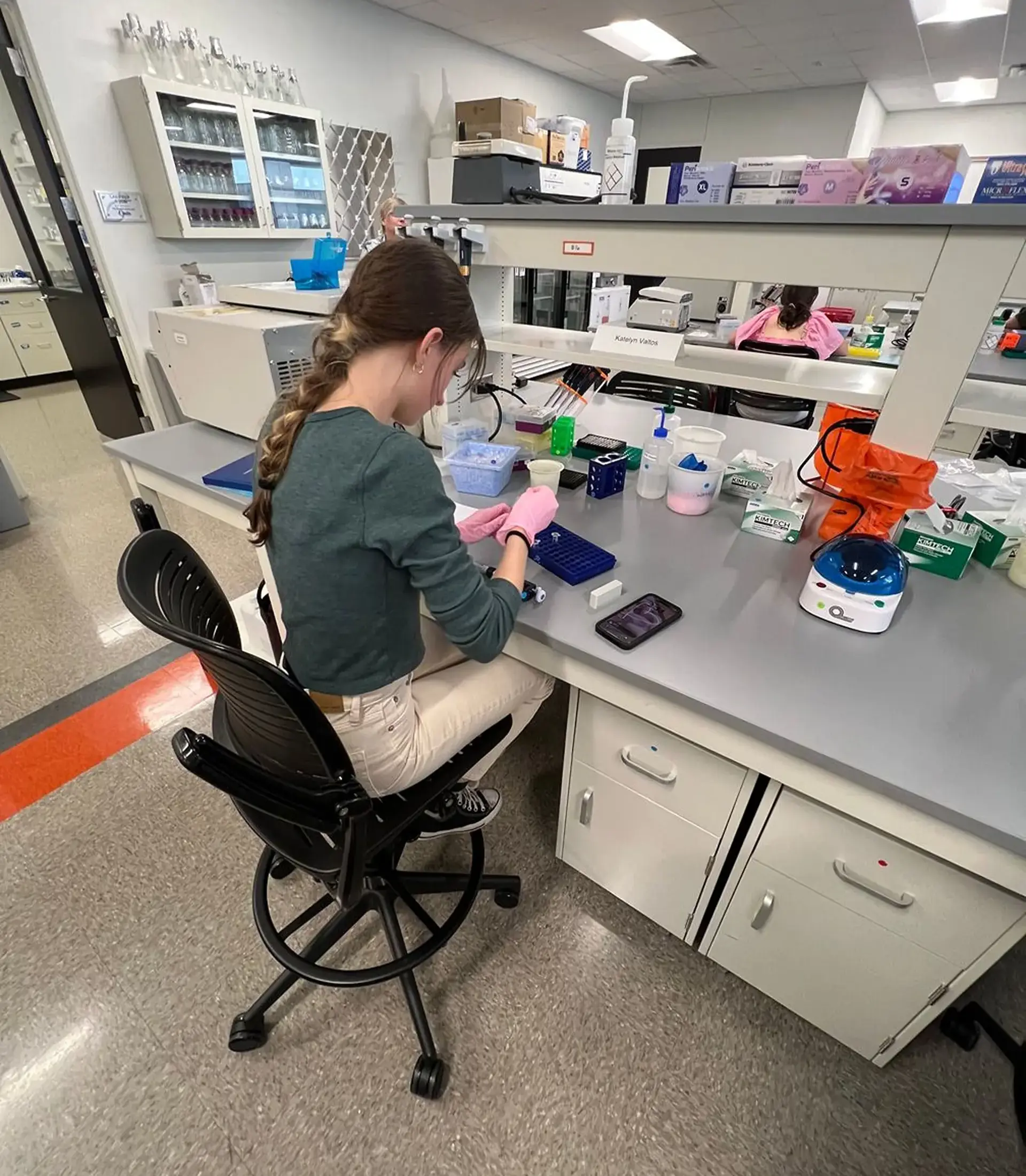 Student conducting laboratory work at a science lab workstation.