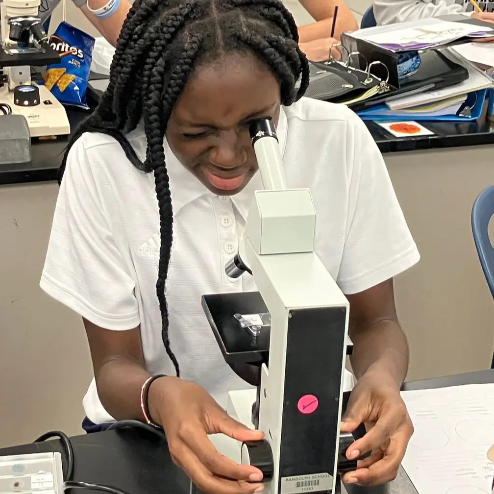 Middle School students looks through microscope. 