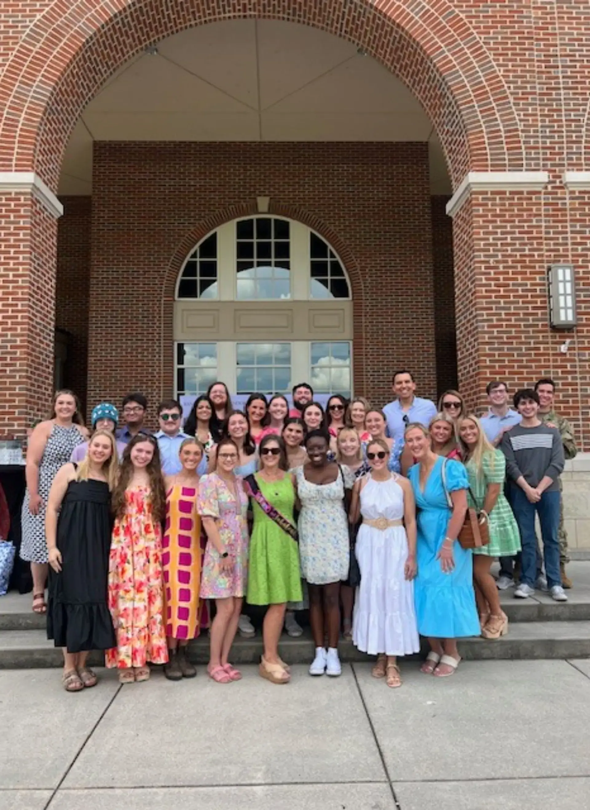 Group of ex-students posing on steps outside Randolph school