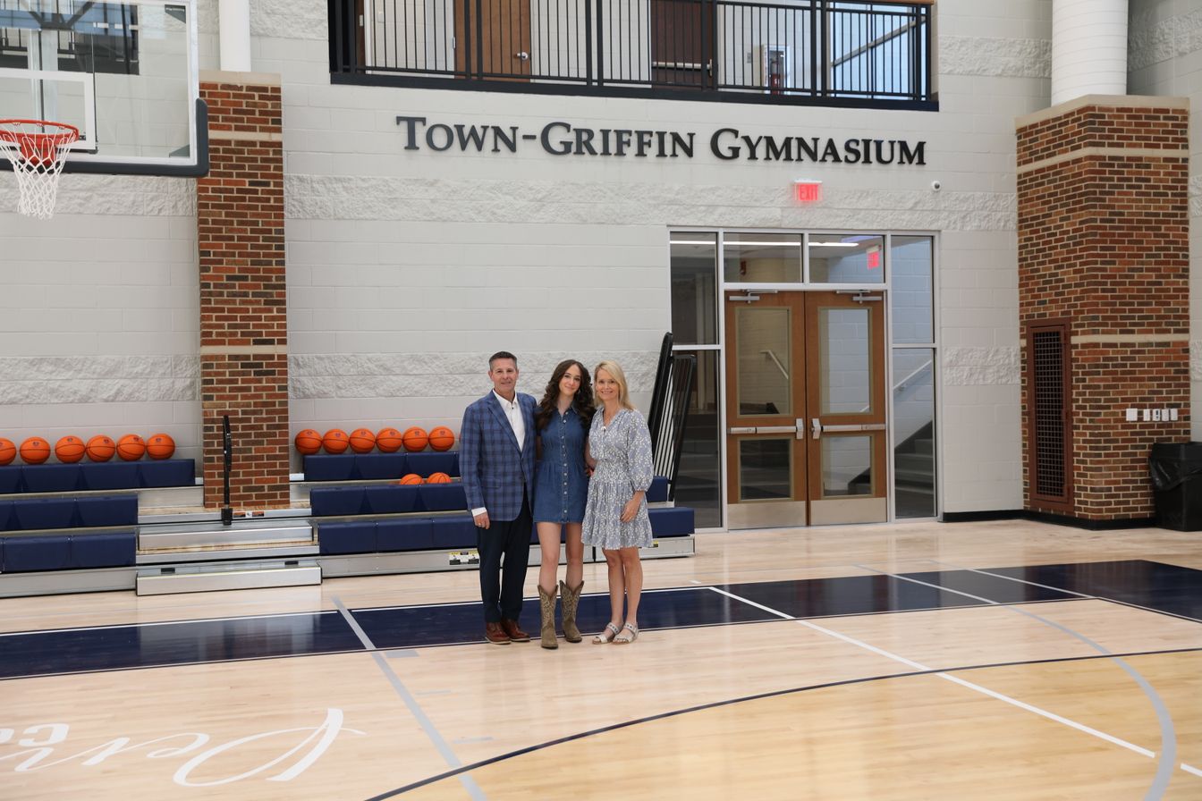 Family poses on the court inside the Town-Griffin Gymnasium.