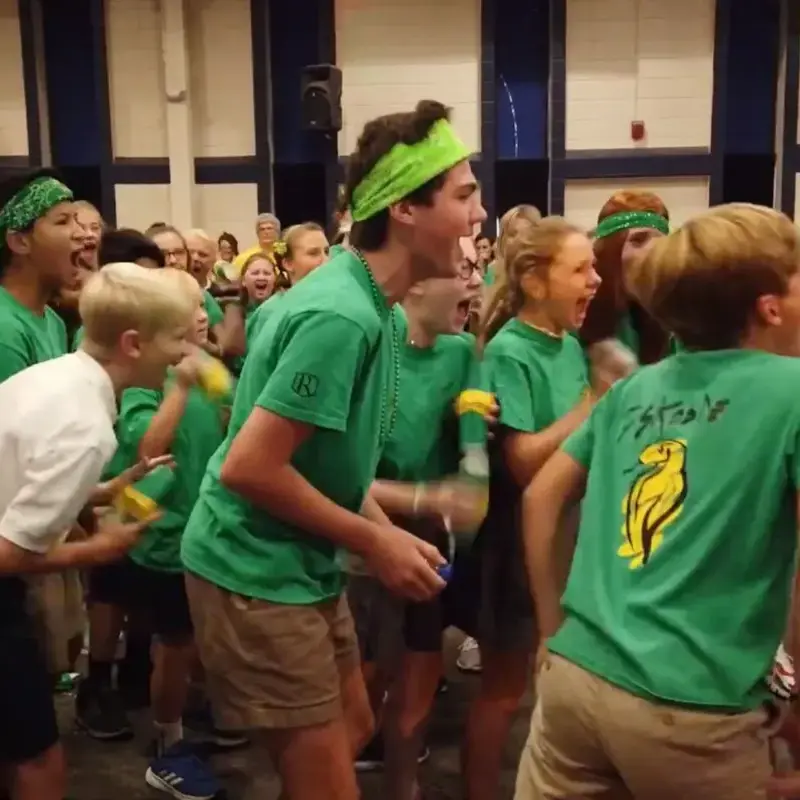 Students enthusiastically cheering and celebrating together during a school spirit event.