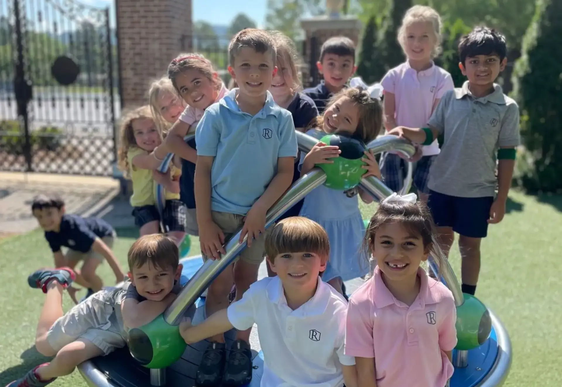 Young students smiling together on a playground climbing structure.